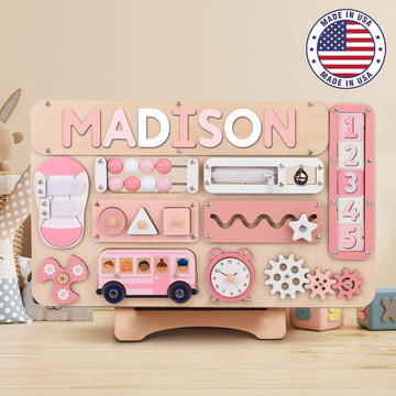 A personalized Montessori busy board for toddlers, featuring rotating numbers and various sensory activities, with the name 'Madison' printed on it.